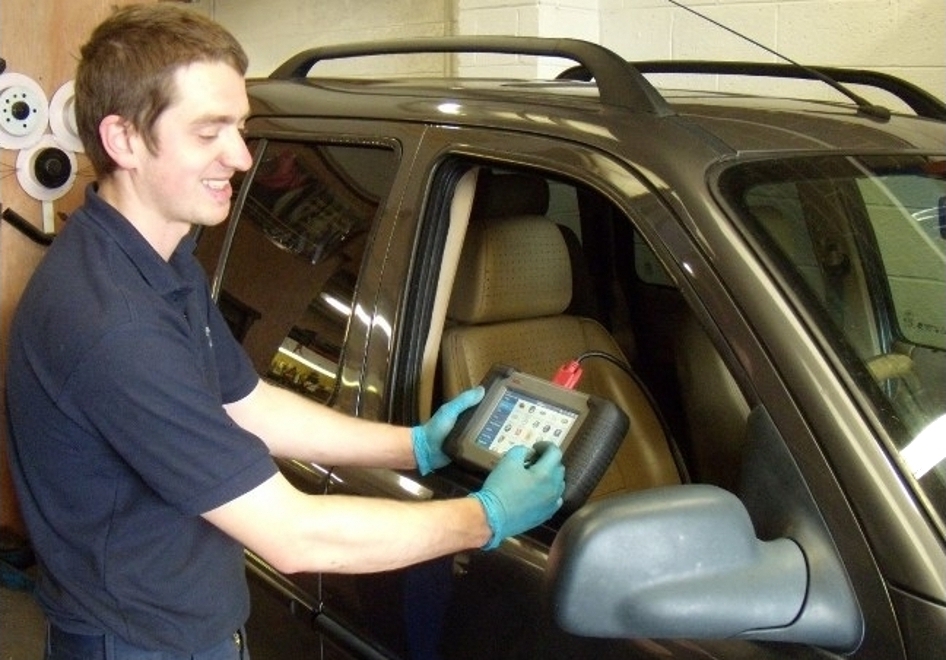 Technician using a diagnostic tablet on a 4x4